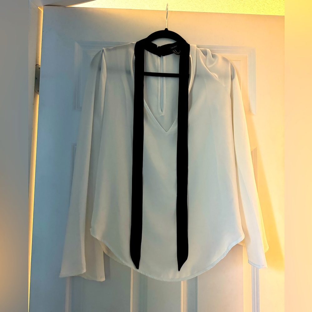White long sleeve shear top with black neck tie.